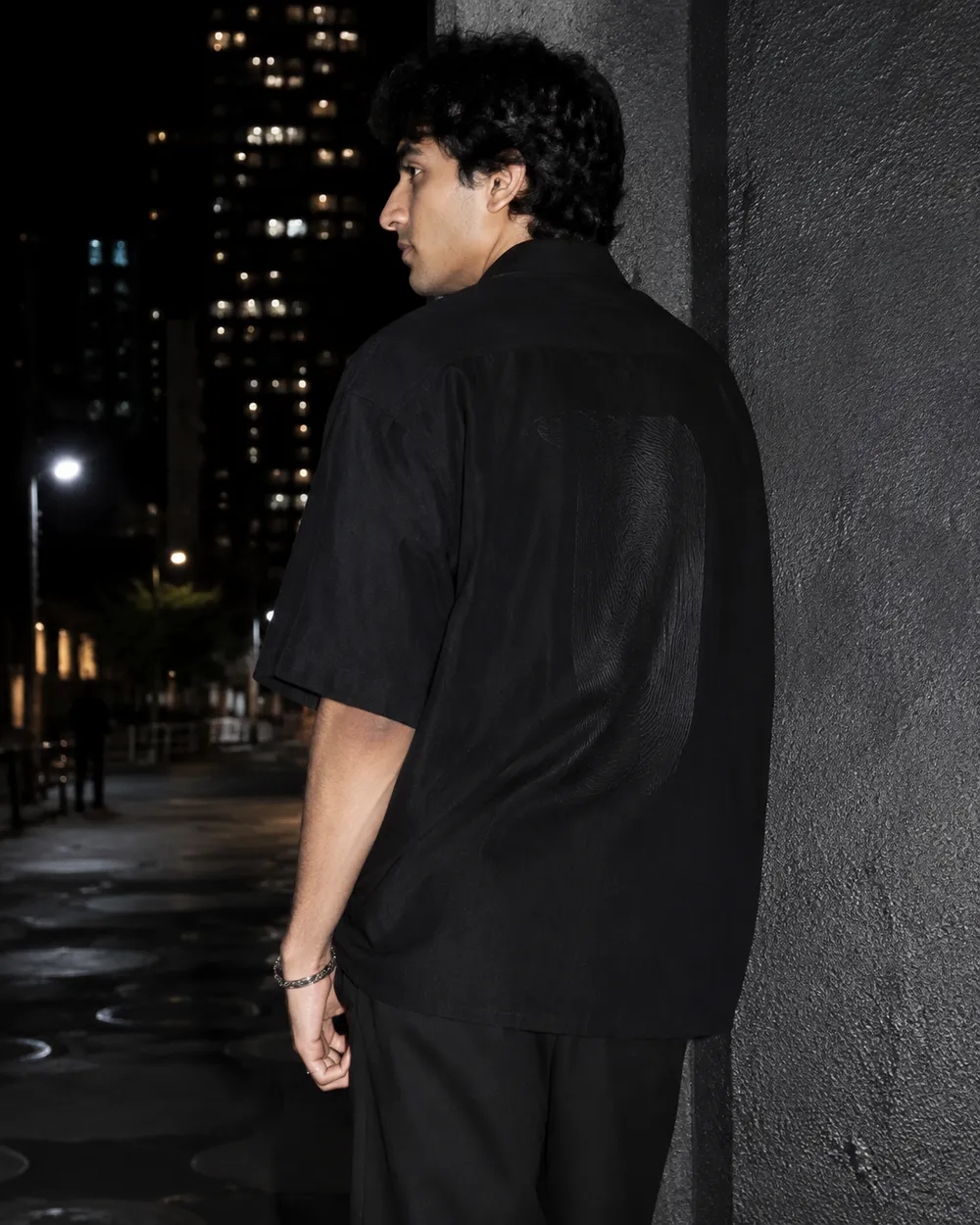 A black oversized silhouette against textured urban concrete